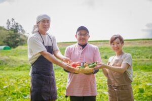 農作物を持って笑顔の農家